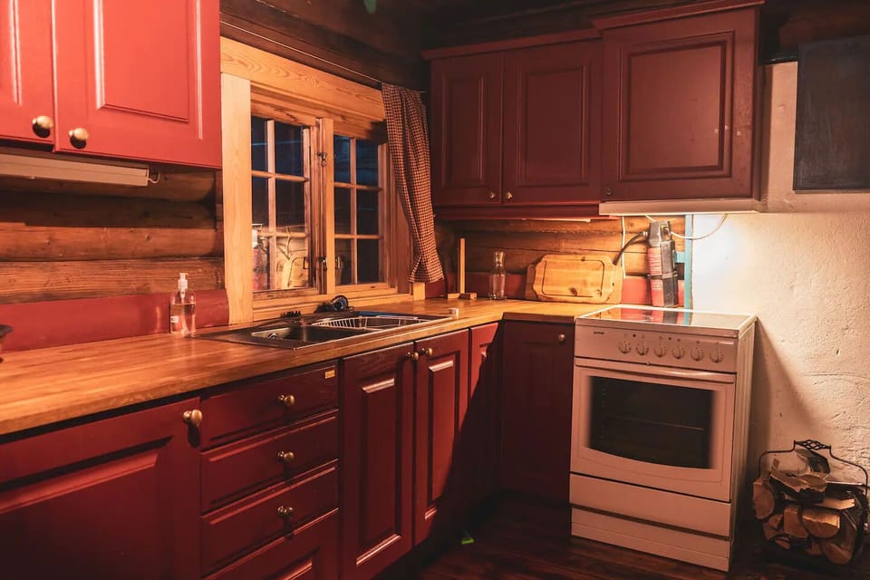 Kitchen has electric stove, fridge, and is fully stacked with cookware