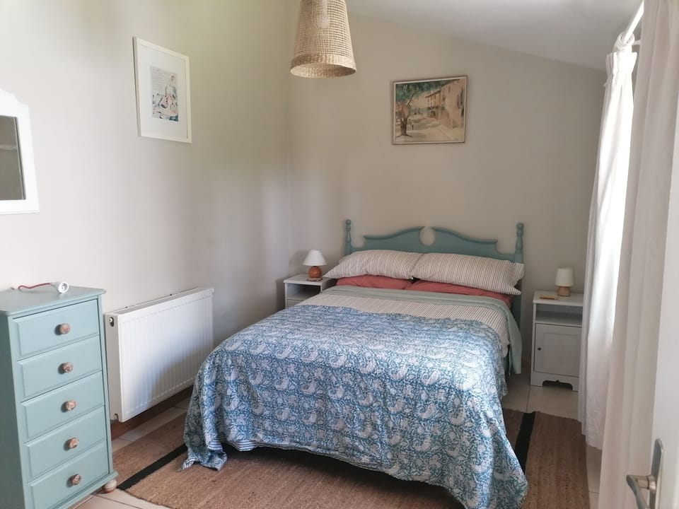 Bedroom 1 has a double bed, drawers, and an area to hang clothes with shelves.