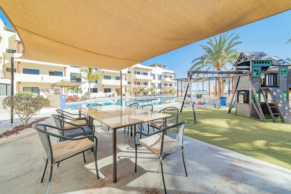 A tranquil patio with a pool and playground, ideal for families