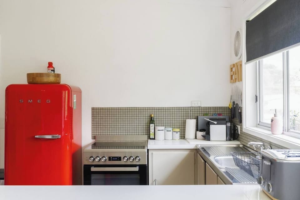 A red Smeg fridge makes a vibrant feature in the open-plan kitchen, which has all you need to cook up a feast, plus a dishwasher for easy clean-up. 