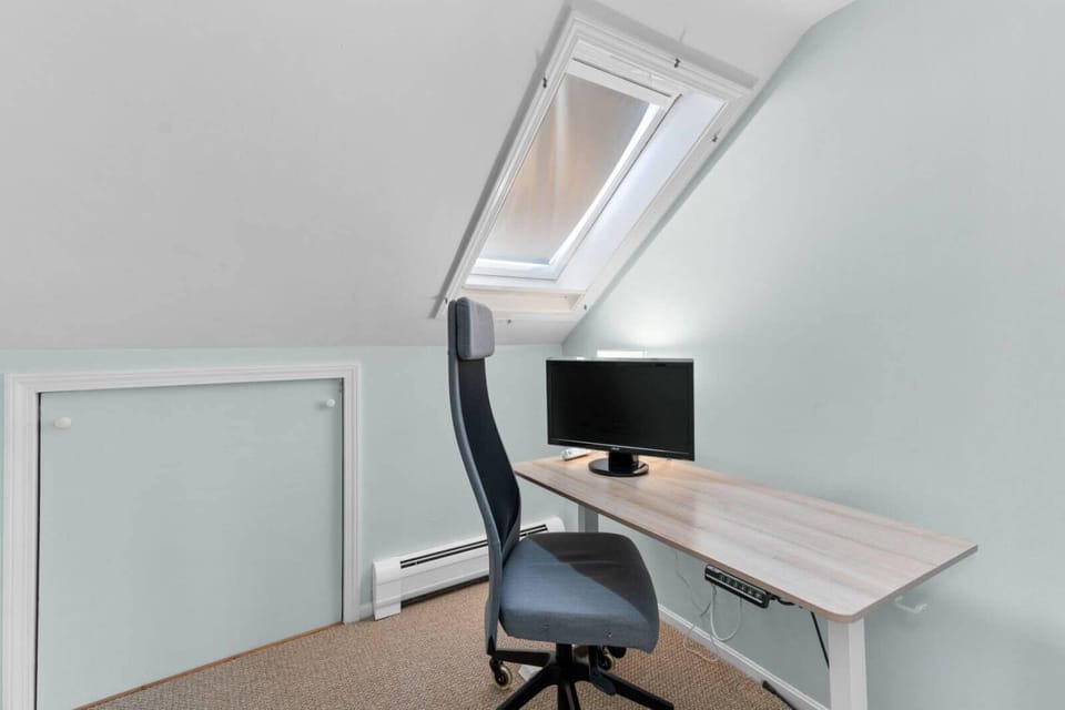 Office with motorized sit/stand desk and 23" monitor