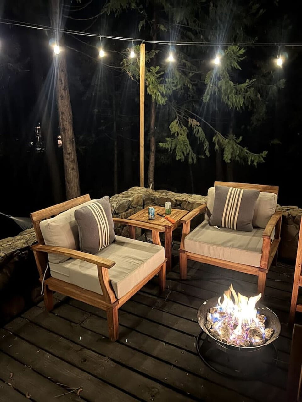 Spacious front deck with original rock wall, outdoor furniture and gas fire ring.