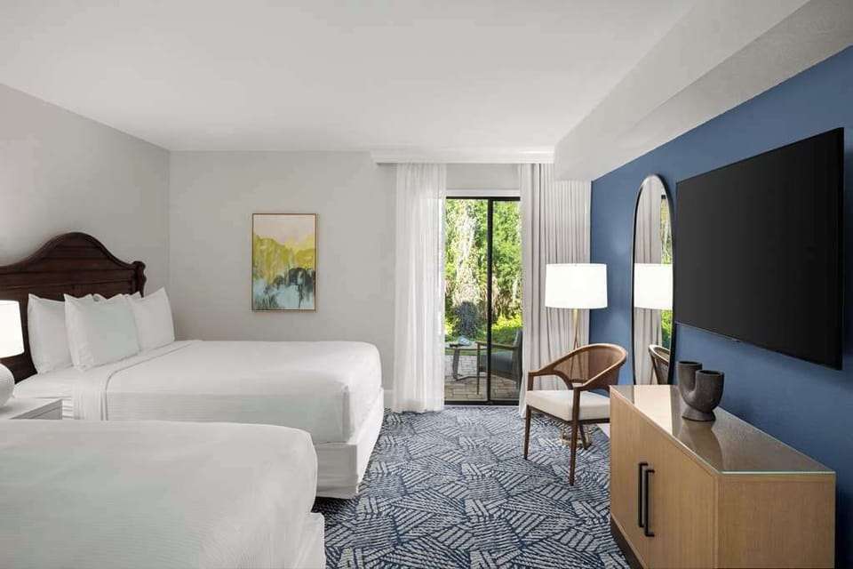 Unwind in two plush queen beds for a restful stay in a bright, serene setting.