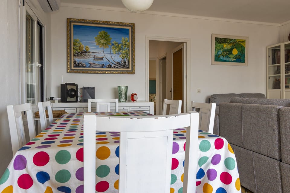 Bright dining area integrated into the living room, featuring a large dining table with seating for several guests. The space connects seamlessly with the seating area and the rest of the home, creating a comfortable and functional setting for shared meals.