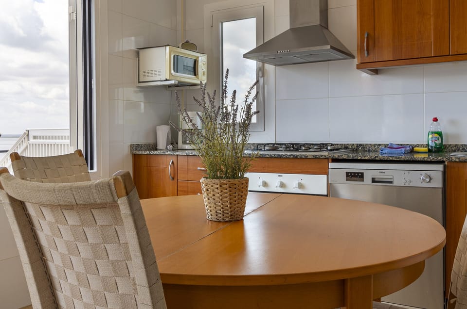 Detail of Villa Maria’s kitchen featuring a round dining table and exterior views. A functional and welcoming space, fully equipped and filled with natural light, ideal for comfortable meals during your stay.