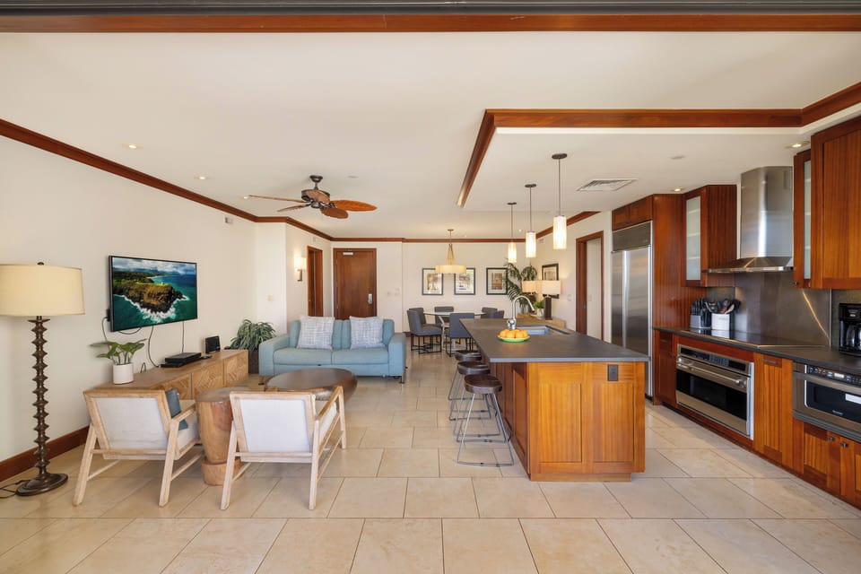 Relax in your open-concept living space where warm wood tones meet modern comfort—perfect for cooking together and unwinding after island adventures.