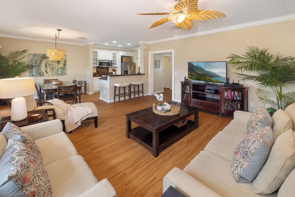 Gather in the elegant living area with tropical accents, ceiling fan, and a 50-inch Smart TV for movie nights in.
