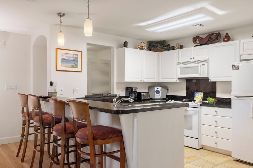 Gather at your open kitchen island with full appliances, sleek countertops, and breakfast bar seating—your home base for easy vacation meals and morning coffee before adventures begin.