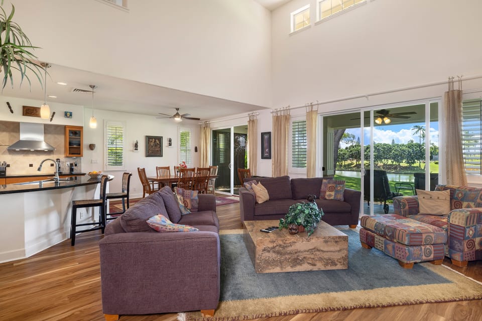 Relax in the spacious living room with soaring ceilings, plush seating, and seamless indoor-outdoor flow overlooking the golf course.