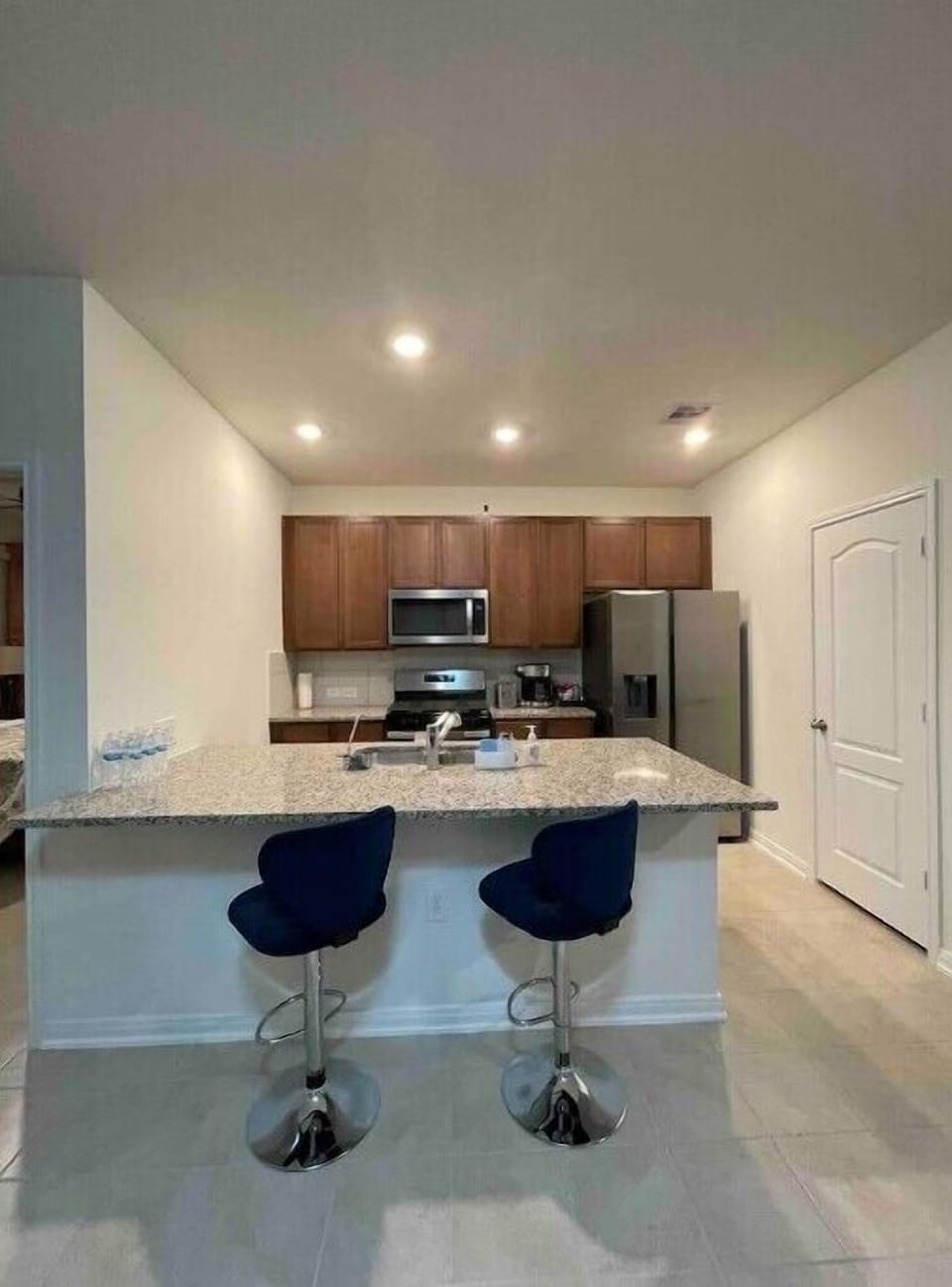 Kitchen with counter top and bar stools