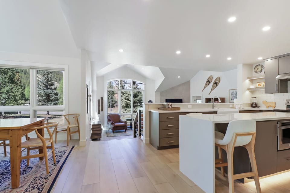 Bright, open-concept living with vaulted ceilings and views of lush pine trees. Your culinary getaway awaits in this modern kitchen, perfect for gathering around the island or dining by the windows.