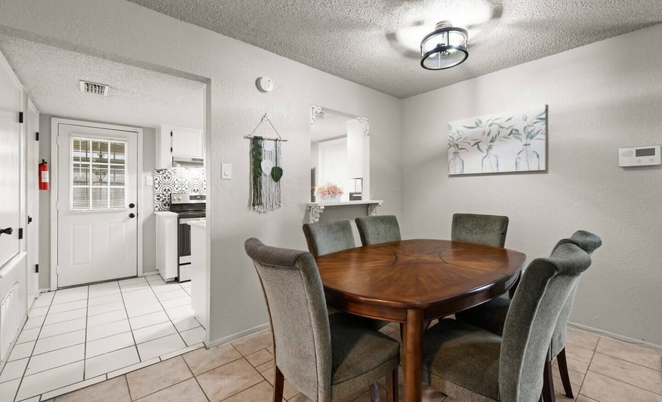 Savor sophistication in our modern dining oasis. Chic wooden table, sleek black chairs, geometric rug. Abstract art adds character. Elevate your dining experience.