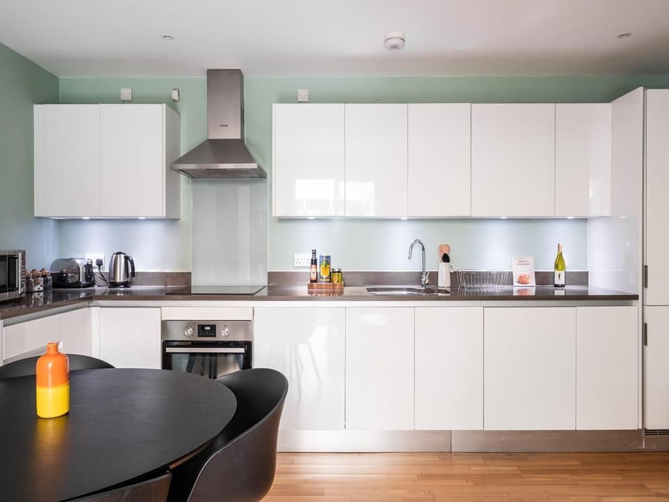 Open plan lounge with sofa, dining , and fully equipped kitchen