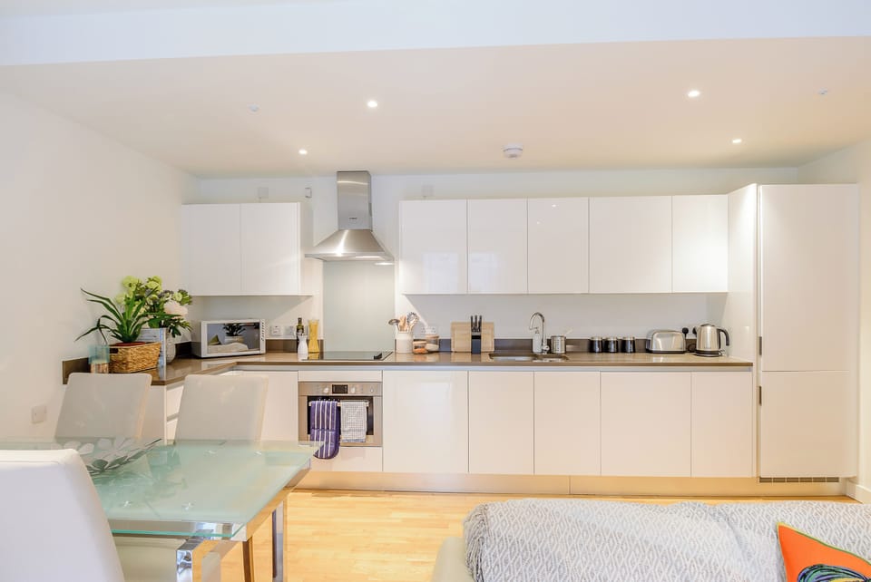 Open plan lounge with sofa, dining , and fully equipped kitchen