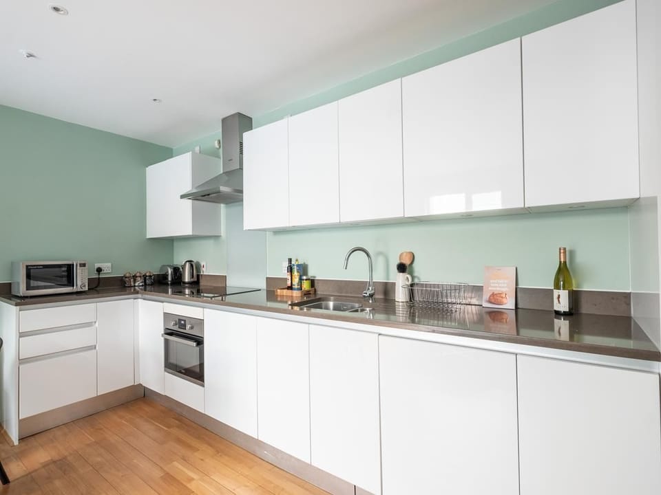 Open plan lounge with sofa, dining , and fully equipped kitchen