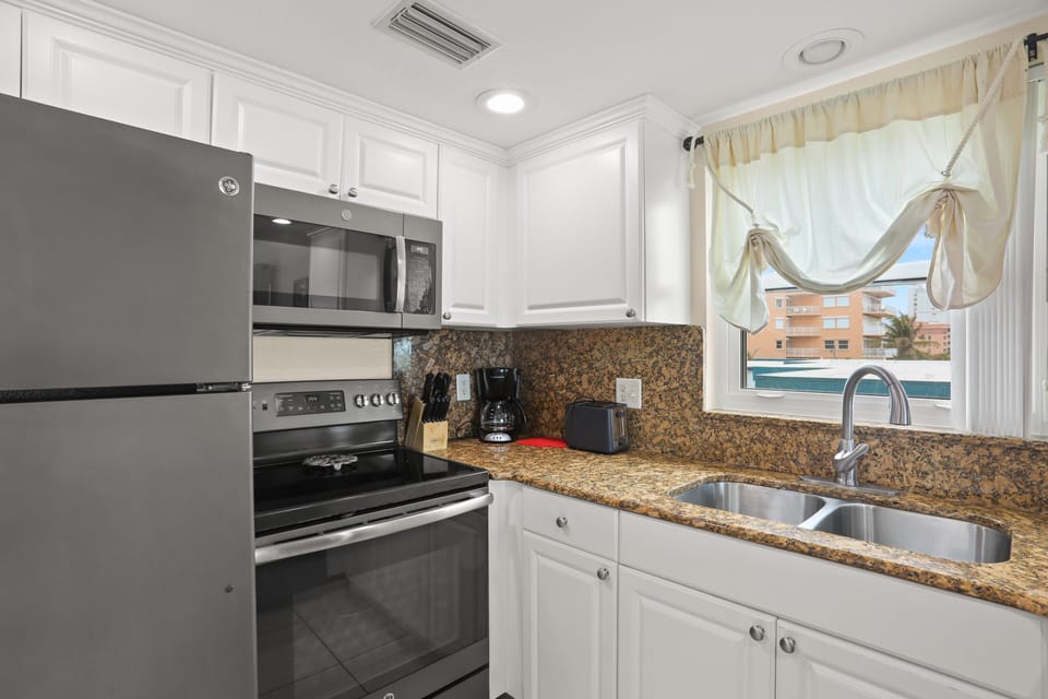 Full Kitchen With Stainless Steel Appliances.