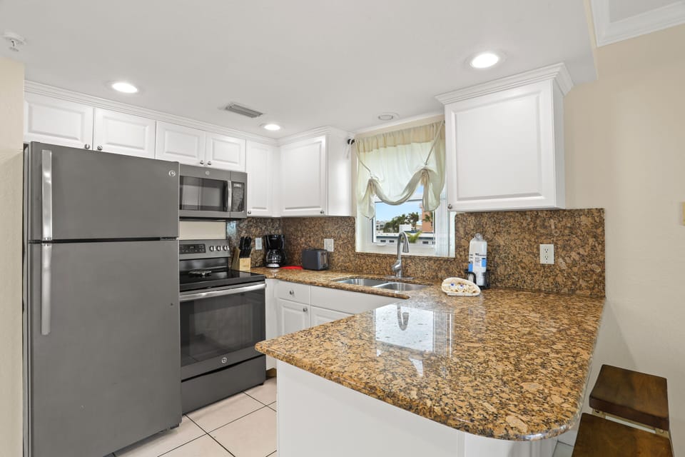 Full Kitchen With Stainless Steel Appliances.