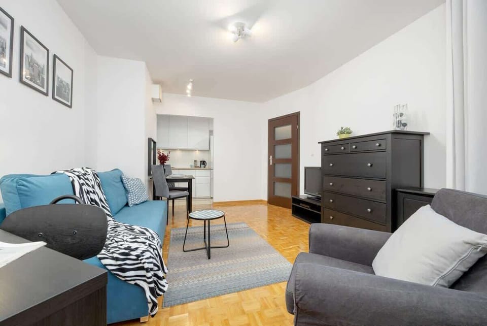 A spacious living area with a comfortable gray armchair, a black dresser, and tasteful furnishings, offering both comfort and sophistication.

