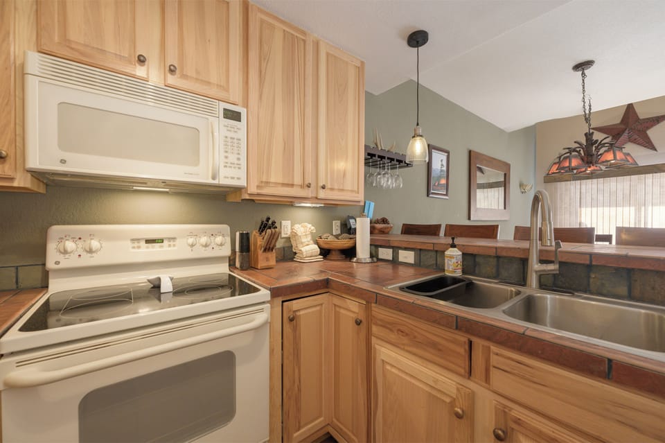 Your fully equipped kitchen features beautiful wood cabinetry and modern appliances, perfect for preparing family meals during your stay.