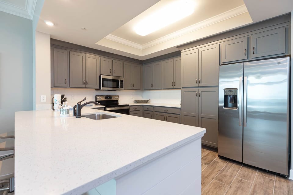 Prepare meals in this kitchen with stainless appliances, spacious counters, and elegant cabinetry