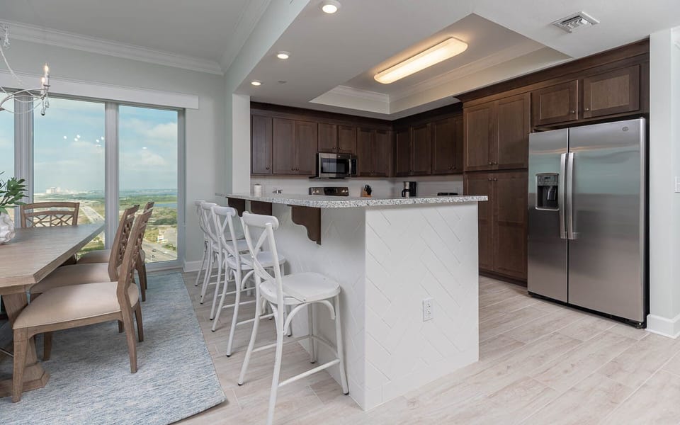 Gather and enjoy gulf coast views through the floor-to-ceiling windows from this inviting kitchen area