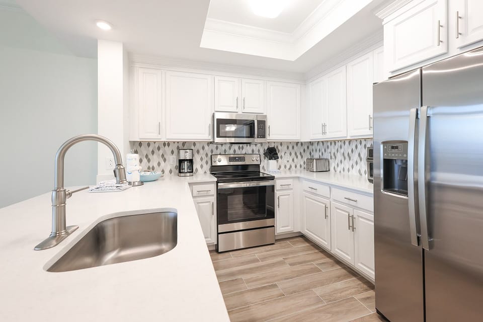Prepare meals in this kitchen with elegant cabinetry, stainless appliances, and stylish backsplash
