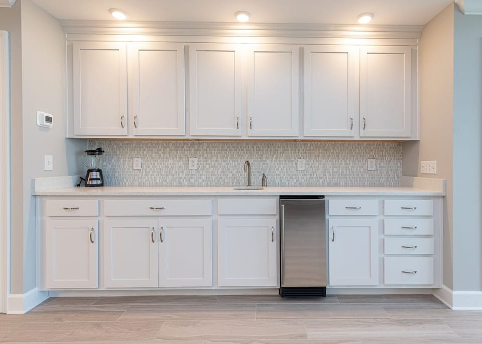 Prep cold drinks at the wet bar, with a smooth countertop, and open the compact undercounter fridge