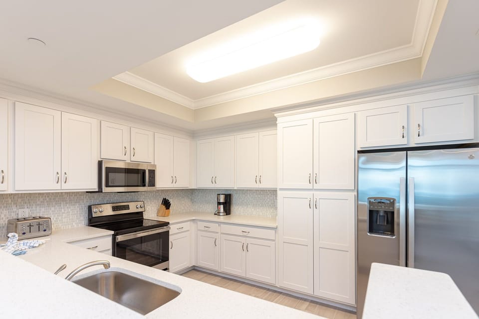 Prepare meals in this elegant kitchen with stainless appliances and white cabinetry