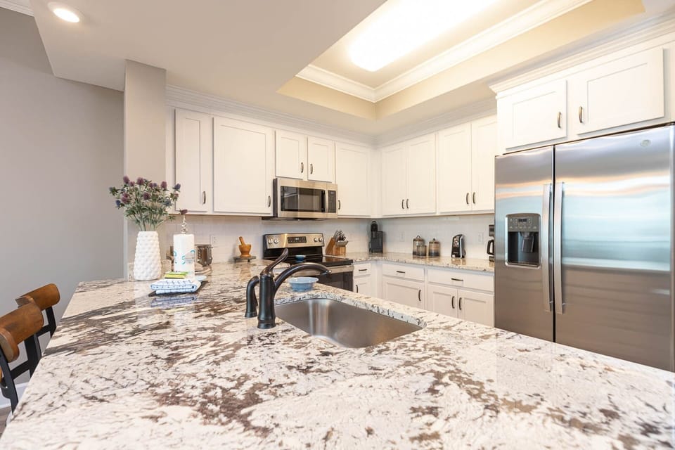 Prepare meals in this kitchen with elegant cabinetry, stainless appliances, and stylish countertops