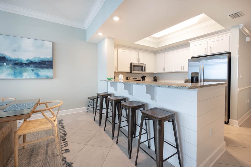 Pull up a bar stool at the breakfast bar to sip morning coffee and chat overlooking this stylish kitchen