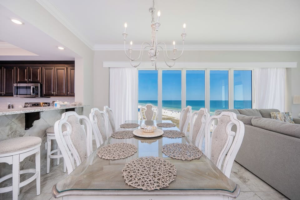 Imagine sipping a cool drink at the table while floor-to-ceiling windows frame the gulf and beach