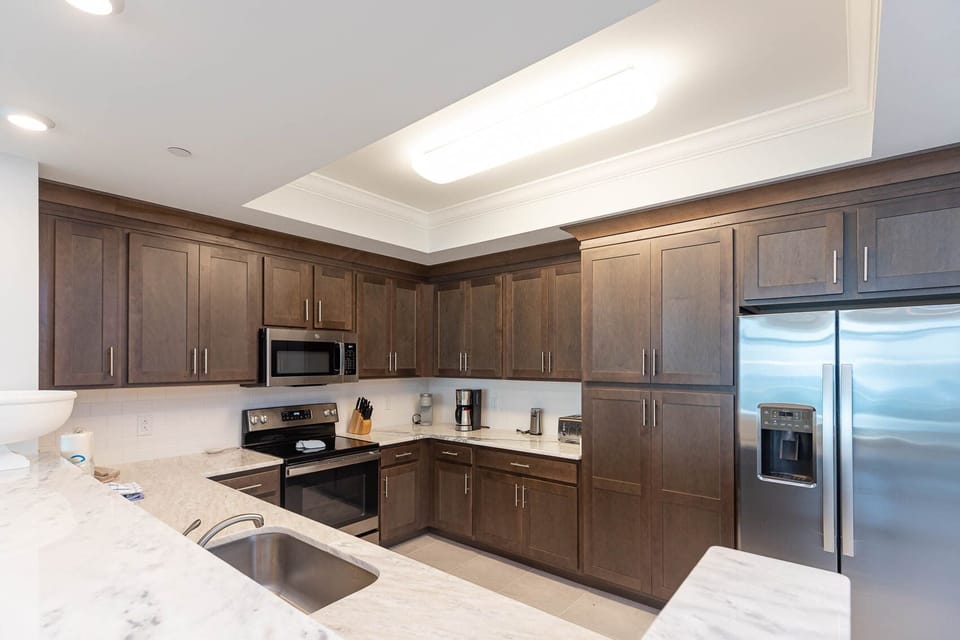 Prepare meals in this kitchen with elegant cabinetry, stainless appliances, and spacious countertops