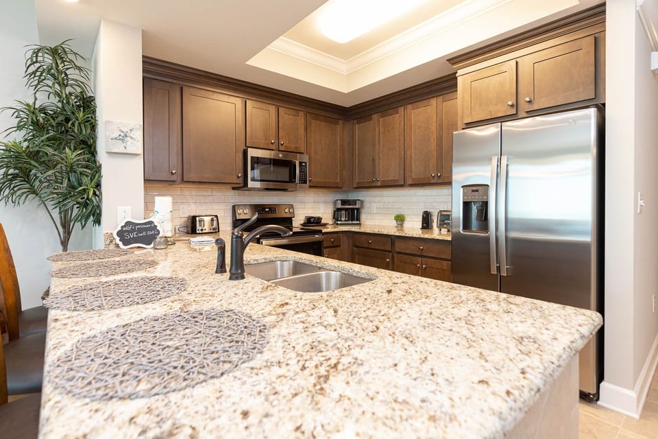 Prepare meals in this kitchen with elegant cabinetry, stainless appliances, and spacious countertops