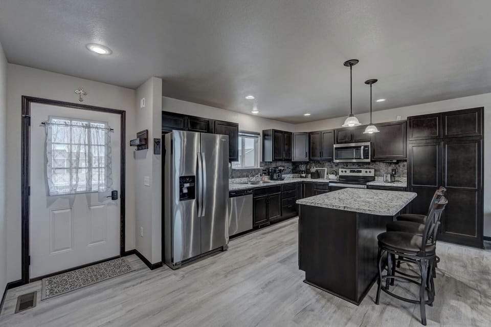 Open kitchen with large island for extra dining seating, stocked with almost everything you might need to cook for your family or group during your stay. 
