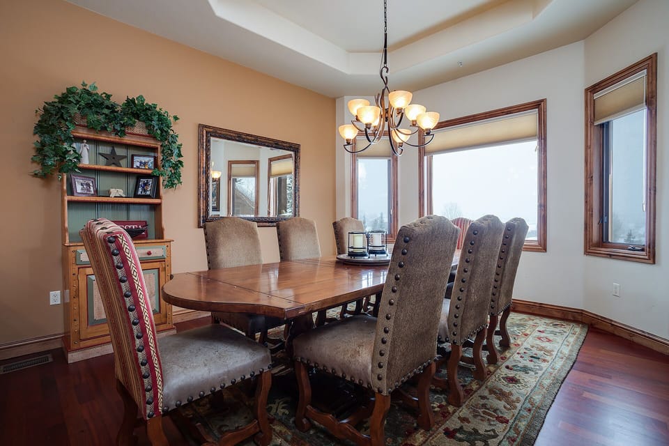 Gather around this elegant dining table where memorable meals await, bathed in natural light from expansive windows.
