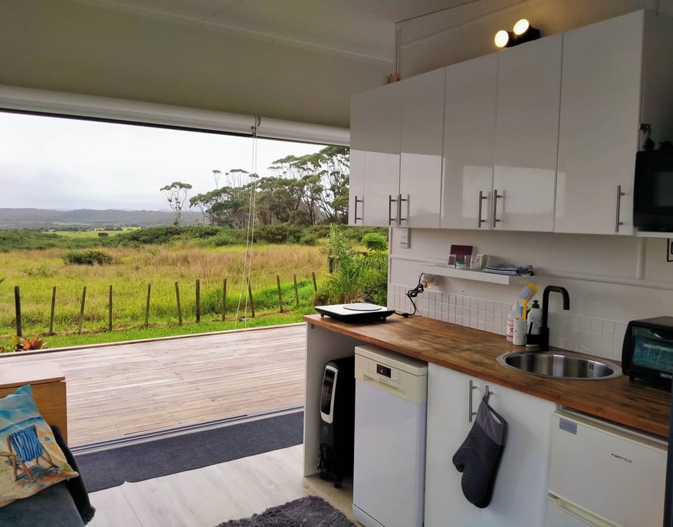 Kitchenette with 6m stacker slider doors + ocean, country + golf course views.