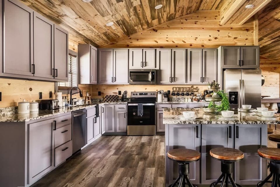 Modern kitchen with granite countertops and rustic wood ceiling for a cozy cooking experience