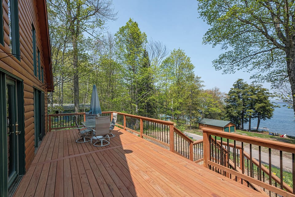 - Spacious deck overlooking trees and sparkling lake views - Outdoor seating perfect for grilling meals and relaxing - Elevated cabin deck offering peaceful fresh air moments