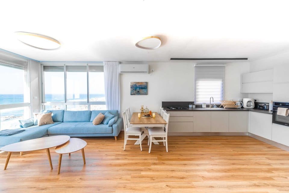 Bright open-plan layout connects cooking, dining, and relaxation spaces overlooking calming ocean views.