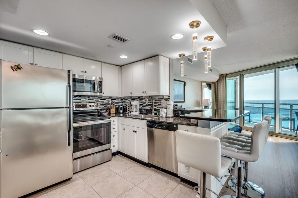 A sleek, modern kitchen with stainless steel appliances and white cabinetry
