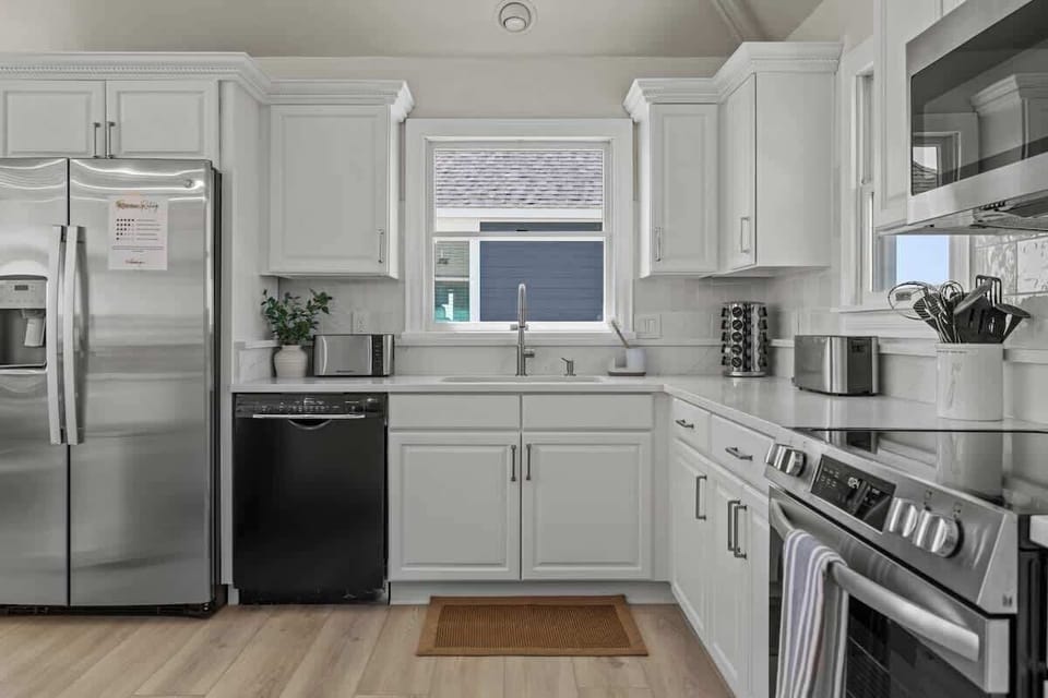 Nicely equipped kitchen with panoramic ocean view has refrigerator, stove, microwave, two dishwashers, blender, Keurig coffee maker, toaster, pots and pans, plates, glasses, wine glasses, coffee cups, spices, cooking and eating utensils.
