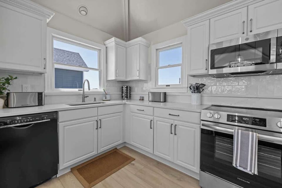 Nicely equipped kitchen with panoramic ocean view has refrigerator, stove, microwave, two dishwashers, blender, Keurig coffee maker, toaster, pots and pans, plates, glasses, wine glasses, coffee cups, spices, cooking and eating utensils.