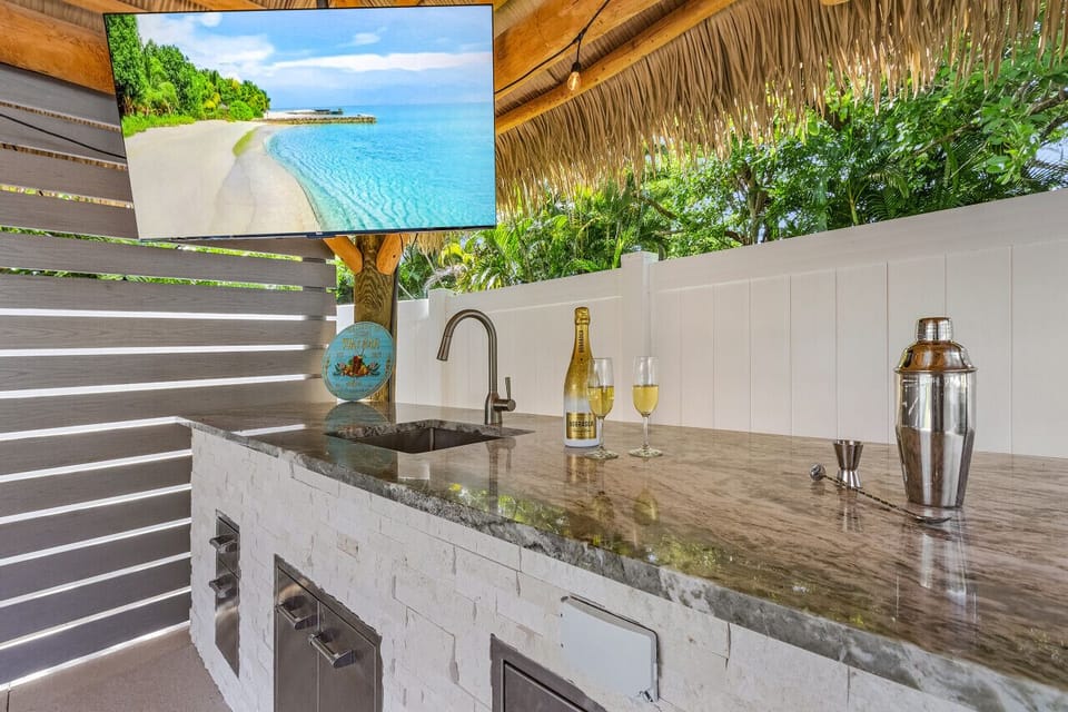 An outdoor tv, sink, cooler and fridge