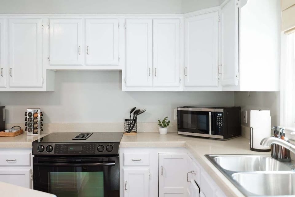 Modern kitchen fully equipped with appliances, cookware, spices, and a Keurig Duo coffee maker
