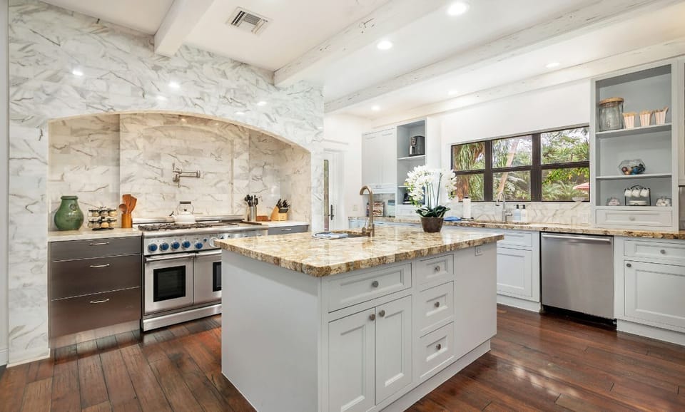 Modern kitchen with marble backsplash and a spacious granite island