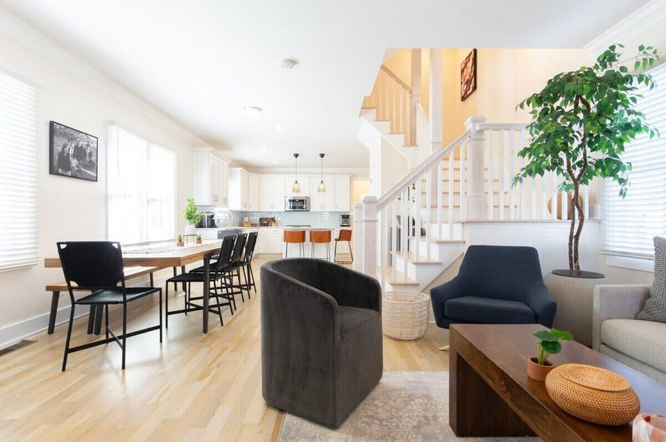 Living Room - beautifully designed living room offers the perfect blend of comfort and style with its hardwood floors and contemporary furnishings. Enjoy a meal at the large dining table or simply unwind in one of the plush accent chairs.