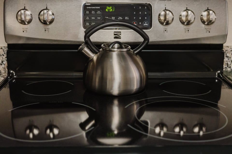 Kitchen stove with stainless kettle ready for your morning brew at A Sleepy Bear Getaway condo in Pigeon Forge, Tennessee — fully stocked for your Smoky Mountain stay