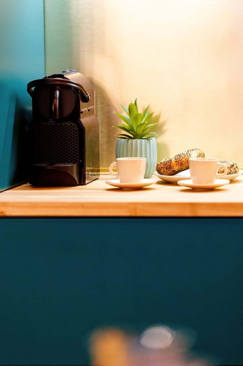 A close-up of a kitchen counter with a coffee machine and warm lighting.

