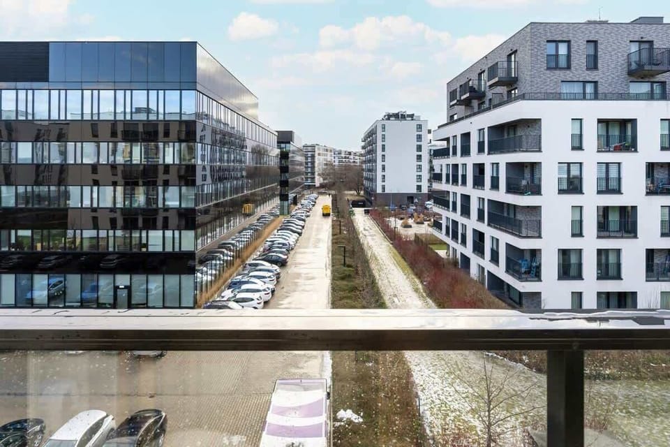 Another outdoor view showcasing the modern buildings and the green courtyard. The layout of the apartments and the landscaping provide a calm and orderly atmosphere.