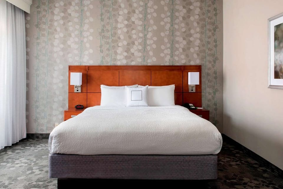 Unwind in a crisp king bed with soft, quiet comfort.